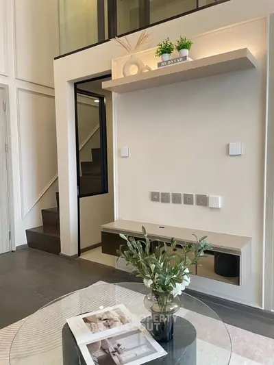 Modern living room with stylish decor and staircase in elegant apartment