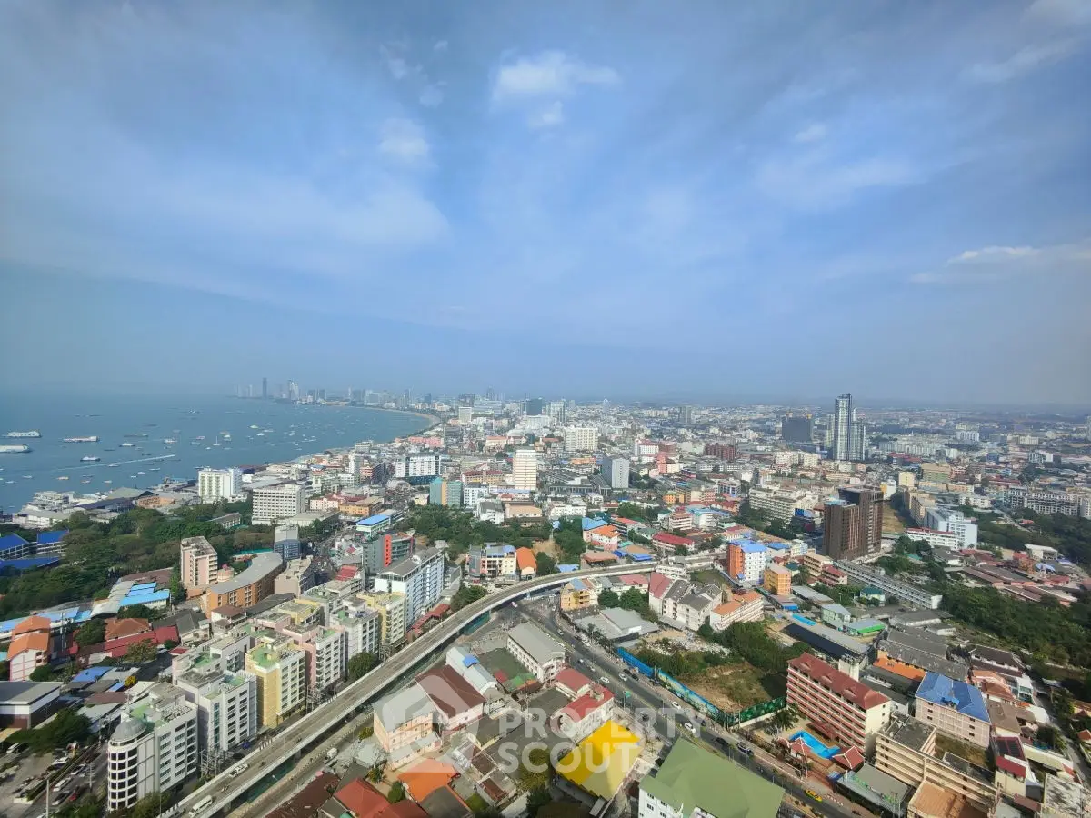 Stunning aerial view of a coastal cityscape with vibrant buildings and expansive ocean horizon.