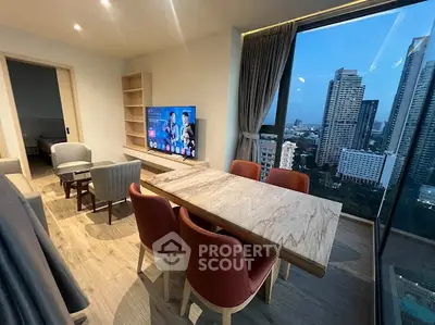 Modern living room with city view, stylish furniture, and large windows in a high-rise apartment.