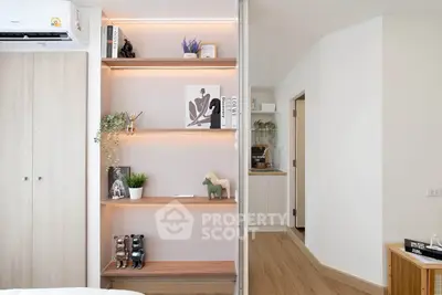 Modern living room with stylish shelving and wooden flooring, featuring elegant decor and natural light.