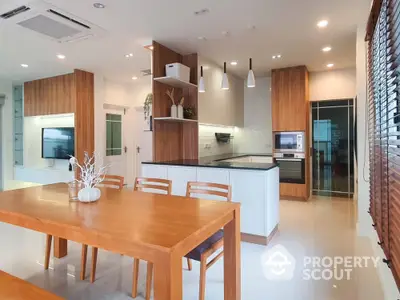 Modern kitchen and dining area with sleek wooden finishes and open layout