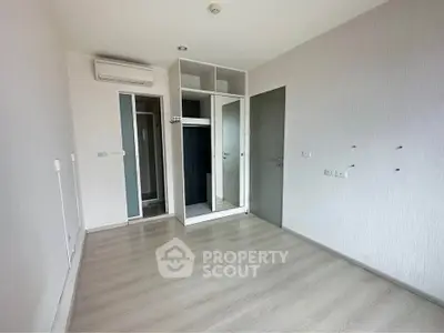 Spacious empty bedroom with built-in wardrobe and modern flooring