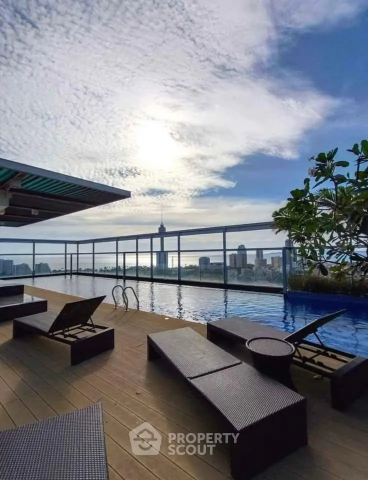 Luxurious rooftop pool with stunning city skyline view and modern lounge chairs.