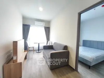Modern apartment interior with cozy living room and bedroom, featuring sleek furniture and natural light.