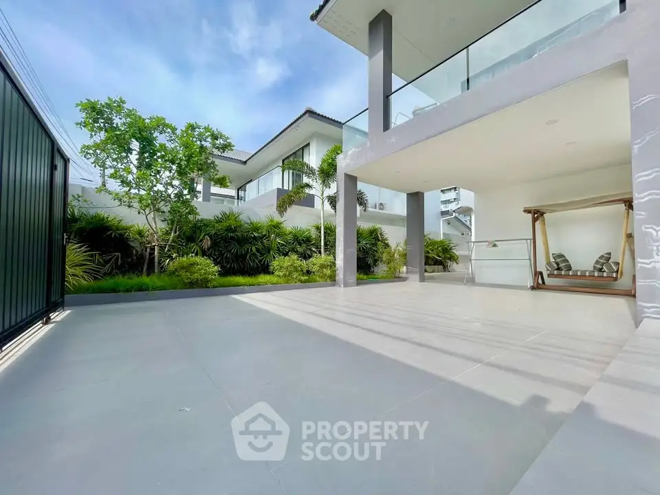 Luxurious modern home with spacious patio and lush garden, perfect for outdoor relaxation and entertainment.