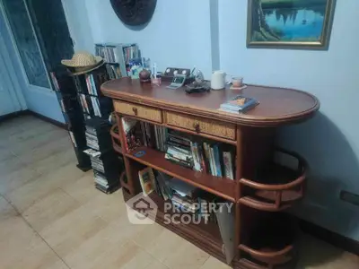 Charming living room with elegant wooden bookshelf and cozy decor, perfect for book lovers.