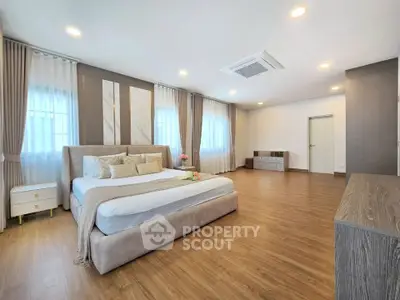 Spacious modern bedroom with elegant decor and wooden flooring