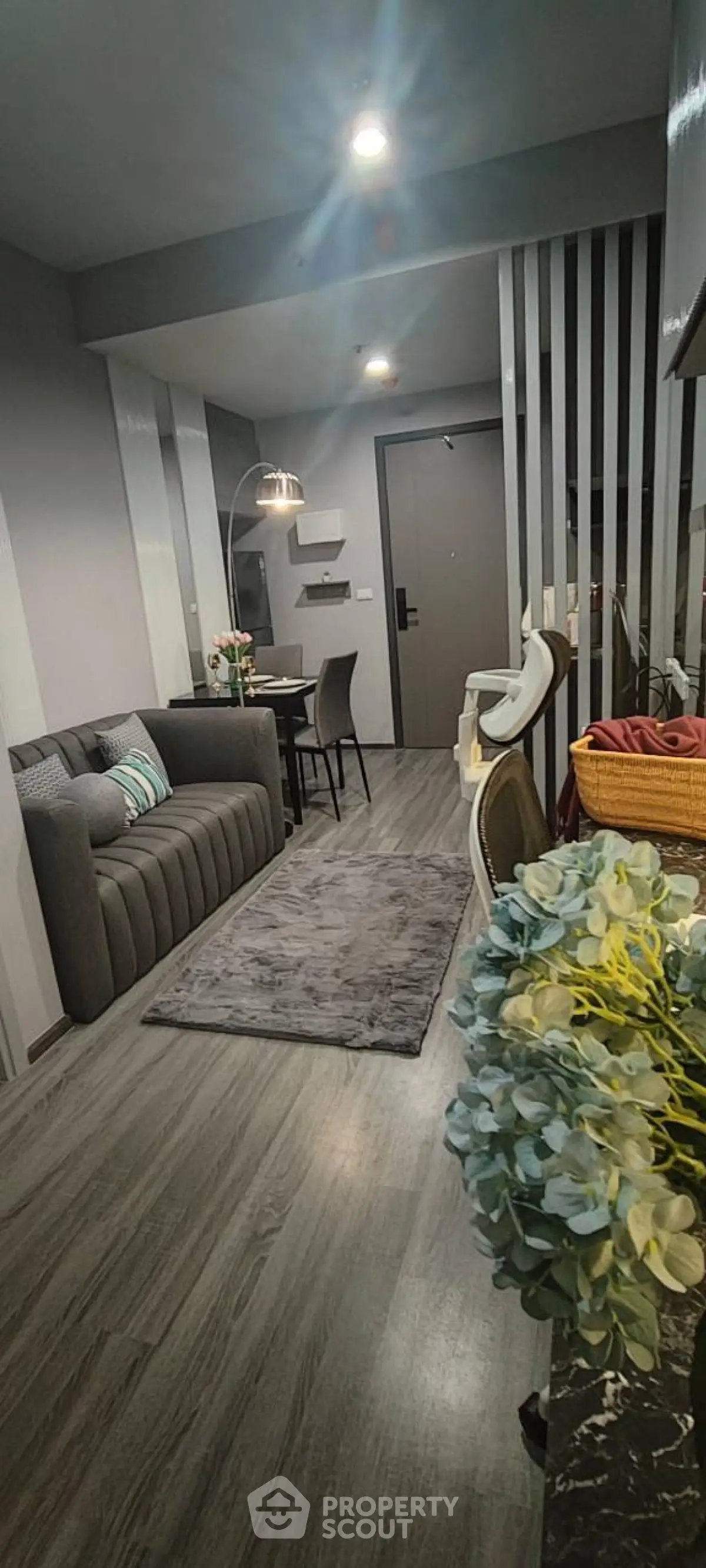 Modern living room with sleek gray decor and cozy seating area.