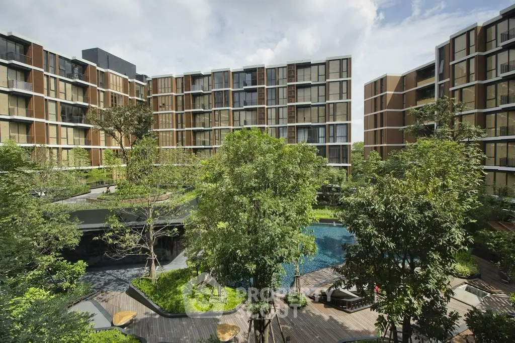 Modern apartment complex with lush greenery and pool view