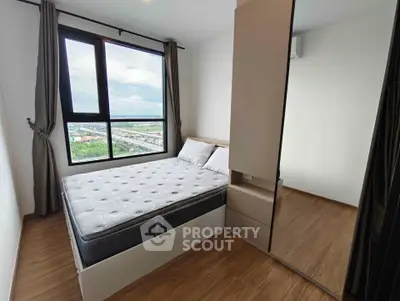 Modern bedroom with large window and mirrored wardrobe offering scenic views.