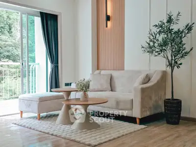 Stylish living room with modern furniture and large window overlooking greenery.