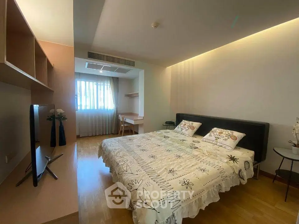 Spacious bedroom with modern decor and natural light, featuring a cozy bed and stylish furnishings.
