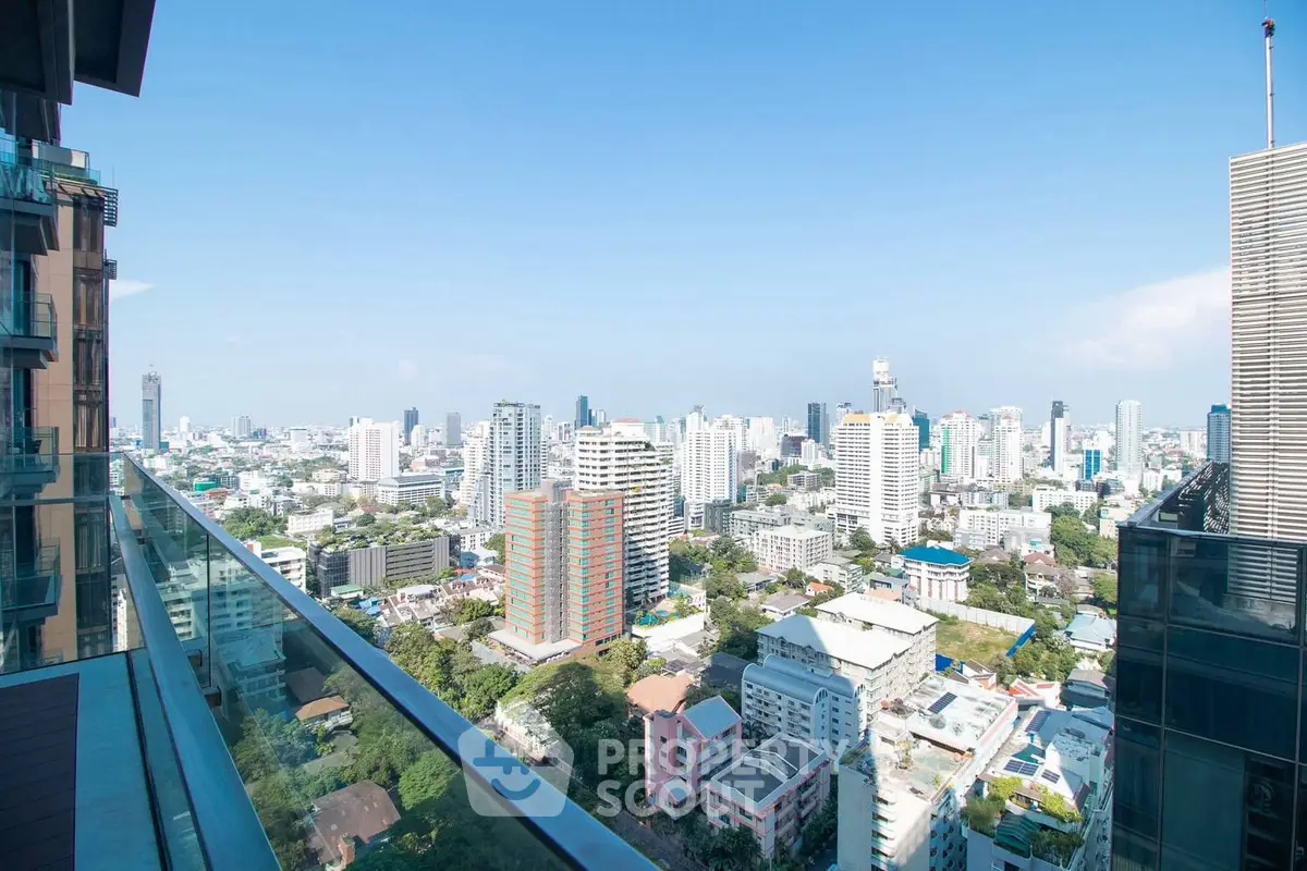 Stunning cityscape view from a high-rise balcony, showcasing urban skyline and clear blue skies.