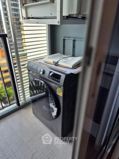 Modern balcony with washing machine and city view, perfect for urban living convenience.
