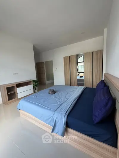 Spacious modern bedroom with stylish wooden furniture and large bed