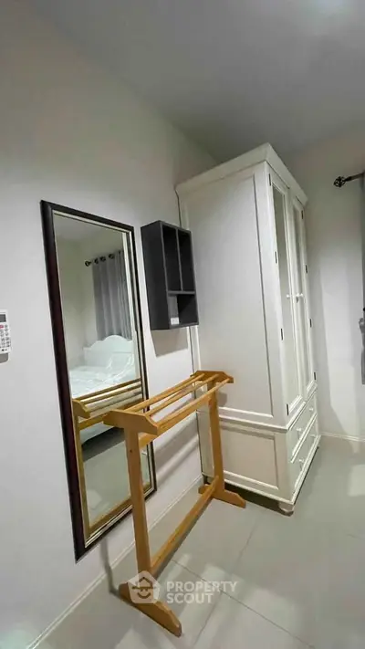 Cozy bedroom with elegant wardrobe and full-length mirror, perfect for stylish living.