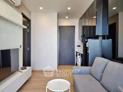 Modern living room with sleek furniture and integrated kitchen appliances in a stylish apartment.