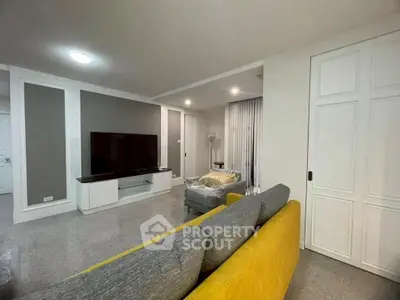 Spacious modern living room with stylish decor and large TV setup