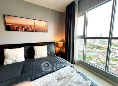 Modern bedroom with large window offering stunning city view, elegant decor, and cozy ambiance.