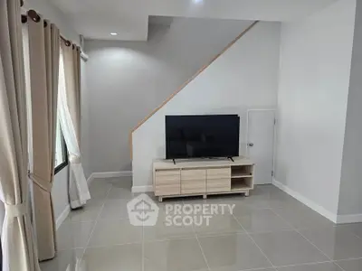 Modern living room with sleek TV setup and elegant curtains