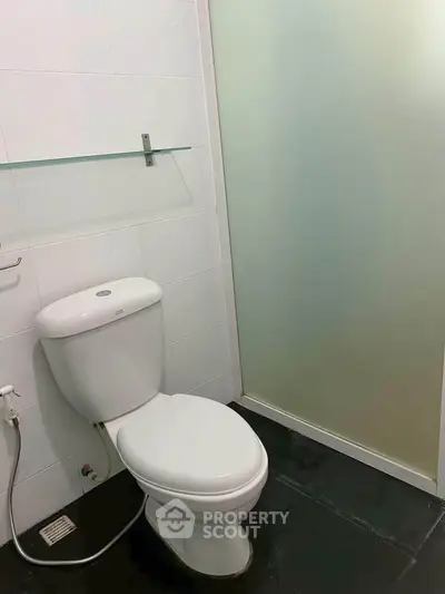 Modern bathroom with sleek design and frosted glass shower door.