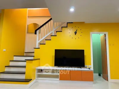 Vibrant living room with modern staircase and wall-mounted TV