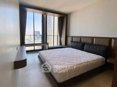 Spacious bedroom with large window offering stunning city views