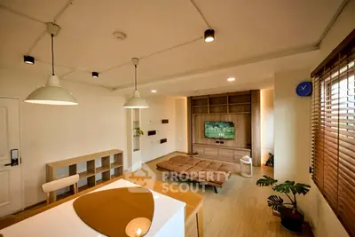 Modern living room with stylish decor and open layout, featuring a cozy seating area and contemporary lighting.