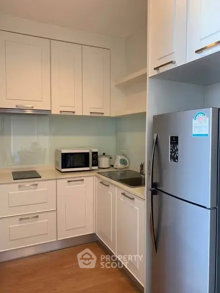 Modern kitchen with sleek white cabinets and stainless steel appliances.