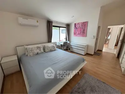 Spacious bedroom with modern decor and natural light, featuring a comfortable bed and stylish furnishings.