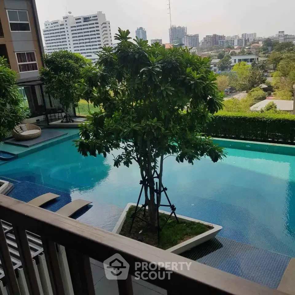 Luxurious apartment pool with lush greenery and stunning city views, perfect for relaxation and leisure.