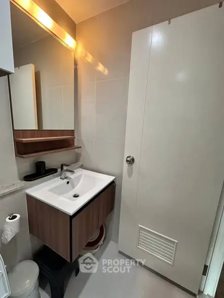 Modern bathroom with sleek vanity and large mirror, perfect for contemporary living.