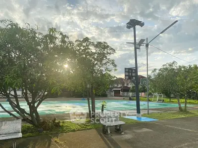 Charming outdoor basketball court with lush greenery and serene atmosphere.