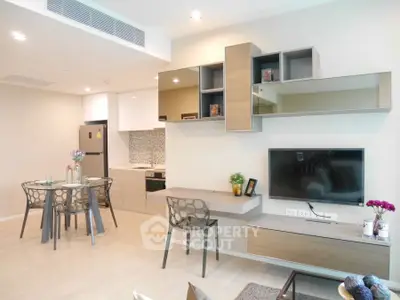 Modern open-plan living room with stylish kitchen and dining area, featuring sleek furniture and contemporary decor.