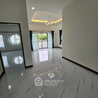 Spacious living room with elegant marble flooring and large windows for natural light.