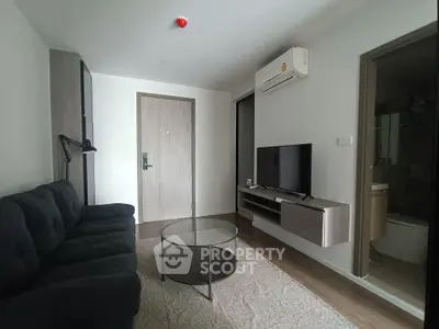 Modern living room with sleek furniture and wall-mounted TV in a cozy apartment.