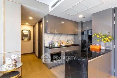 Modern kitchen with sleek cabinetry and marble island in luxury apartment.