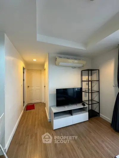 Modern living room with sleek TV stand and air conditioning in a cozy apartment.