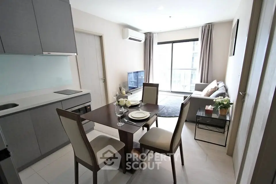 Modern open-plan living room and kitchen with elegant dining area and natural light.