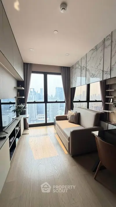 Modern living room with city view, featuring sleek furniture and large windows for natural light.