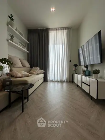 Modern living room with stylish decor, large TV, and elegant flooring, perfect for relaxation.