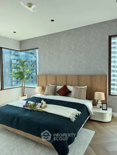 Luxurious bedroom with modern decor and large windows offering city views.