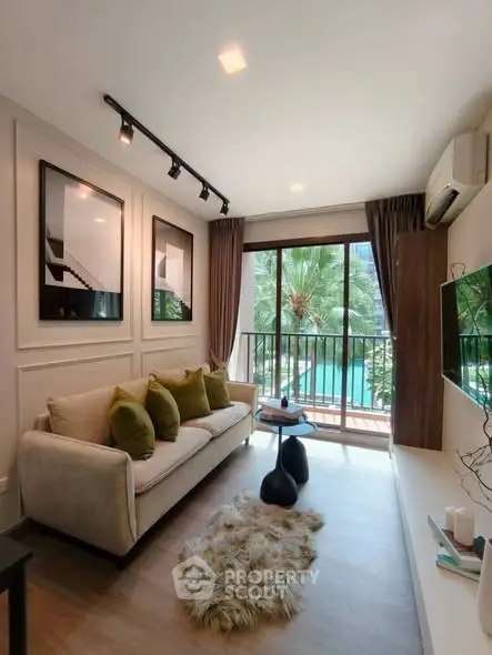 Stylish living room with modern decor and pool view balcony in a luxury apartment.