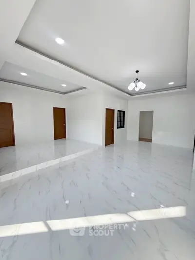 Spacious modern living room with elegant marble flooring and stylish ceiling lights.