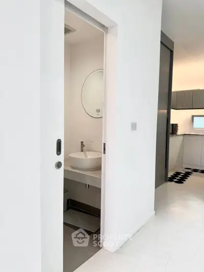 Modern minimalist bathroom with round mirror and sleek white basin