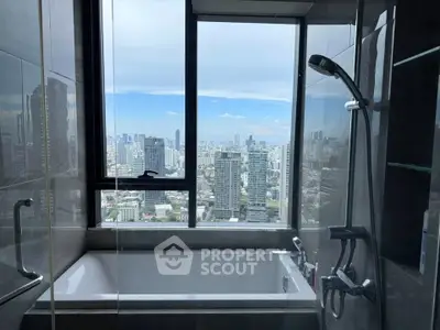 Luxurious bathroom with stunning city view from high-rise apartment window.