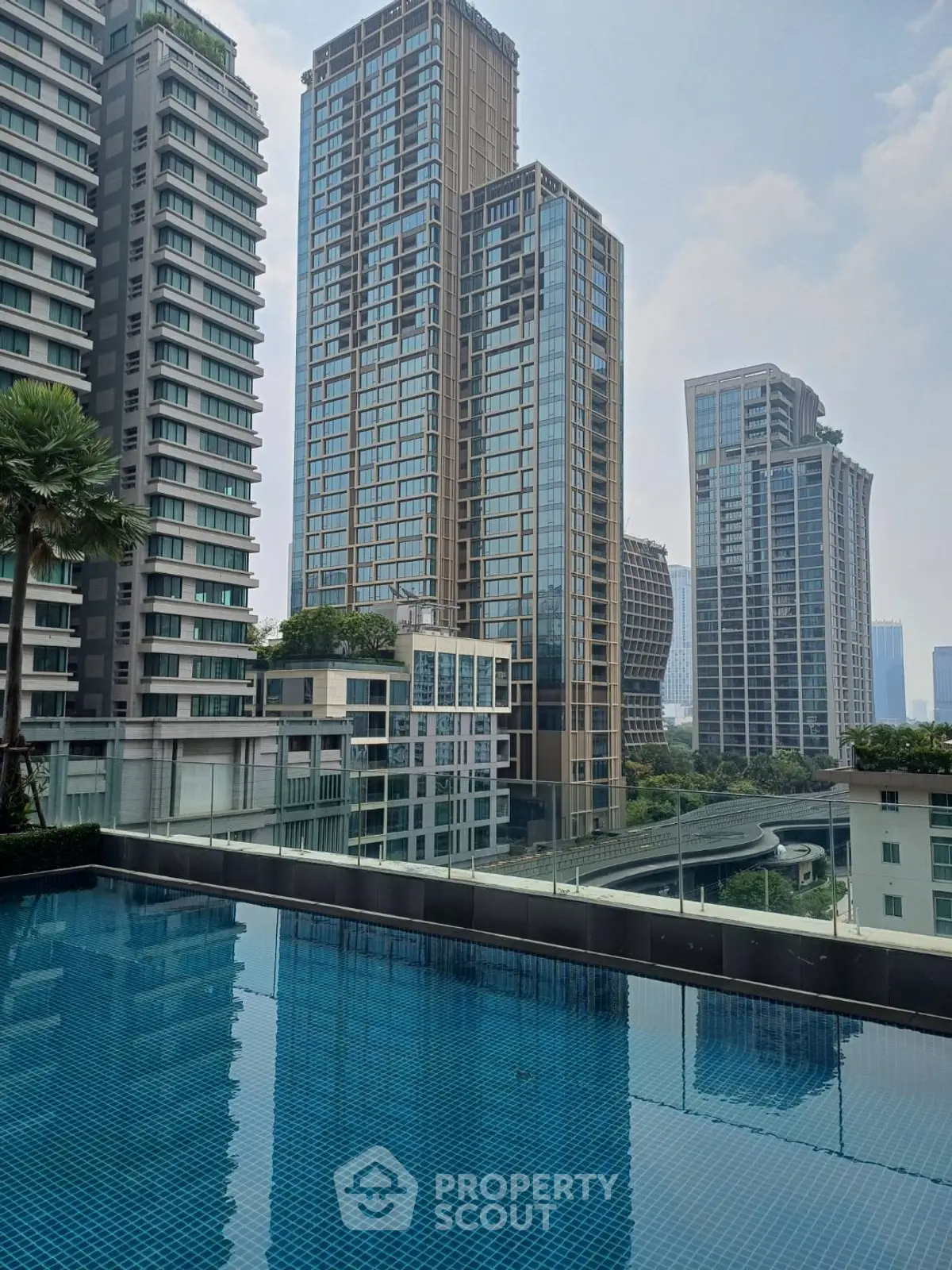 Luxurious urban high-rise buildings with a serene rooftop pool offering stunning city views.