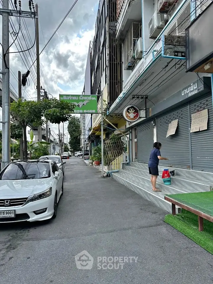 Charming urban street view with commercial buildings and parked car, ideal for business opportunities.