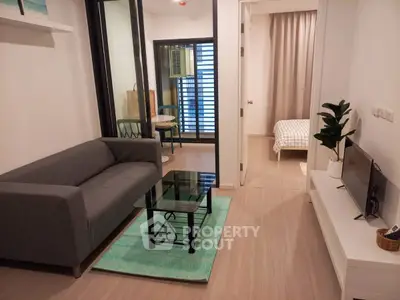 Modern apartment interior with cozy living room and stylish bedroom, featuring sleek furniture and contemporary design.
