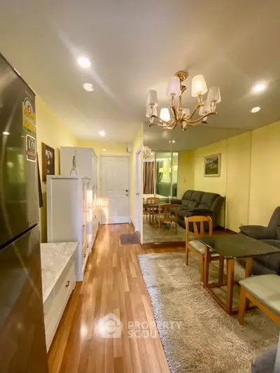 Charming living room with elegant chandelier and cozy seating area, perfect for relaxation and entertaining.